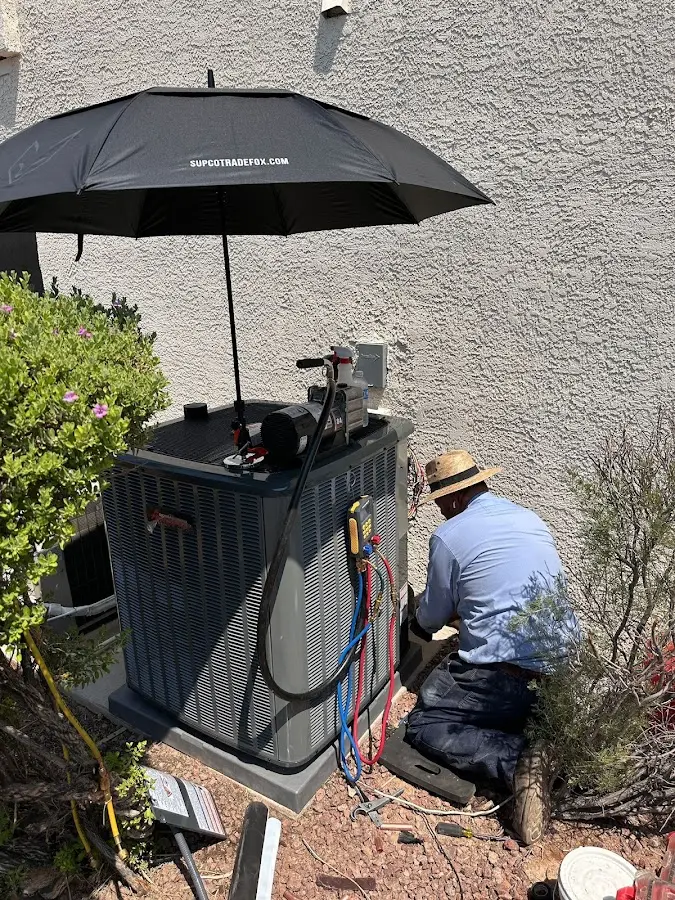 HVAC technician performing outdoor AC maintenance in Whitman